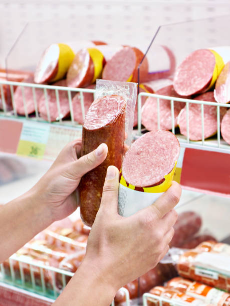 istock Sliced sausage in hands in store 1483225207