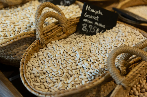 Closeup of dried ganxet beans in wicker baskets for sale on market