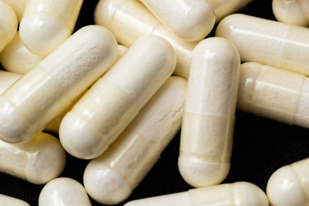 istock Macro Close up of white painkiller tablet on a reflective black background 1483226324