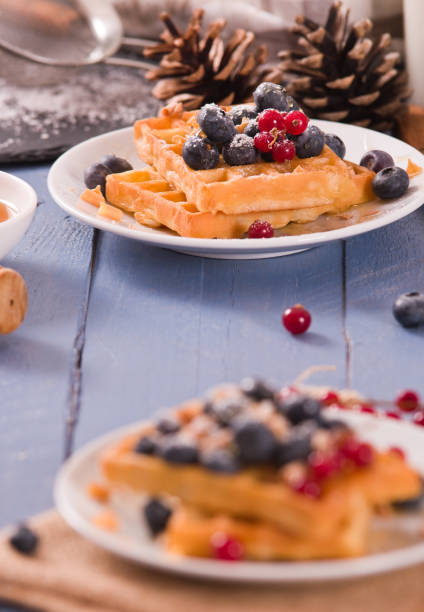 istock Waffles with red currant and blueberries on white dish. 1483227081