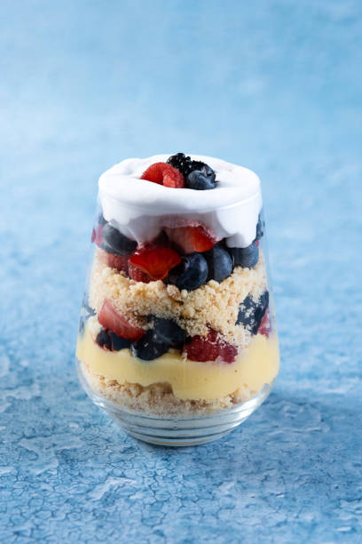 istock Trifle dessert with berries and cream on blue background 1483227908