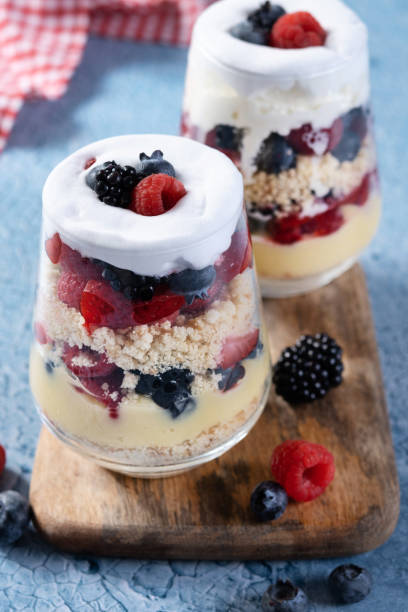 istock Trifle dessert with berries and cream on blue background 1483227936