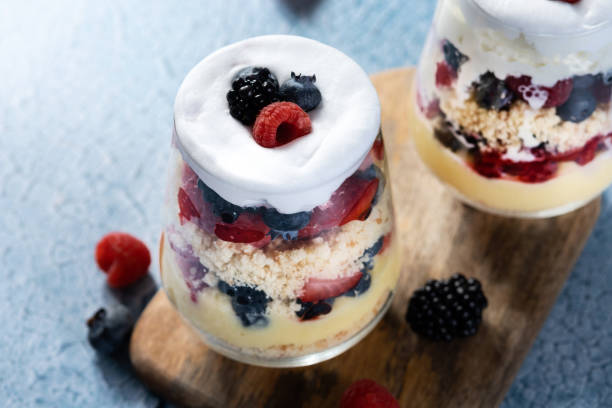 istock Trifle dessert with berries and cream on blue background 1483227959