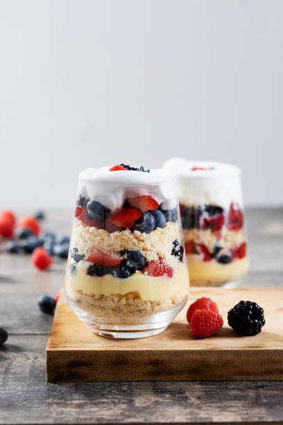istock Trifle dessert with berries and cream on wooden table 1483228063