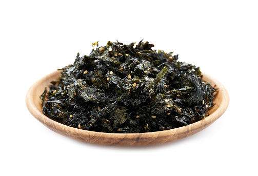 roasted nori seaweed and sesame topping in wood plate isolated on white background. nori laver seaweed crispy isolated on white background. Gim, laver, nori, isolated