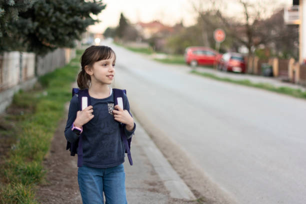istock Schoolgirl whit backpack walking on the road 1483231489