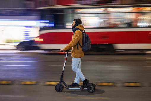 Commuter driving electrical scooter on the bike lane