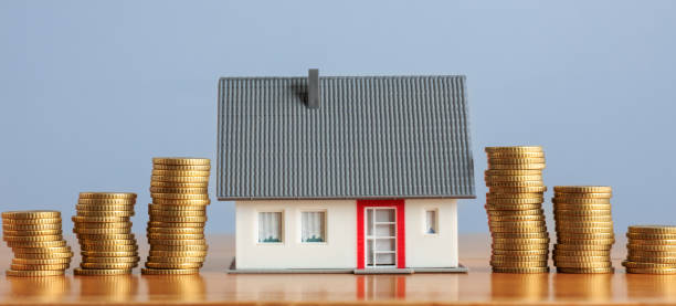 istock Ascending stacks of coins next to a model home 1483231950