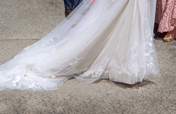 istock beautiful white wedding dress train at a ceremony in spring or summer on rustic concrete pavement 1483233801