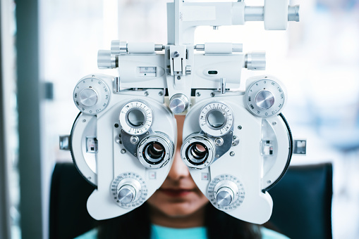 Young female having eye exam in optical shop