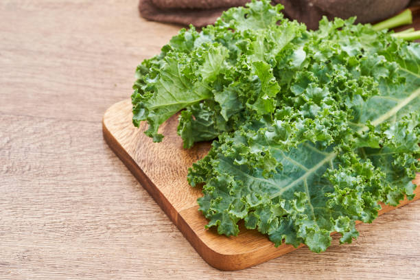 istock fresh green Kale leaves bunch leaf cabbage on wooden table background. green kale or leaf cabbage 1483235016