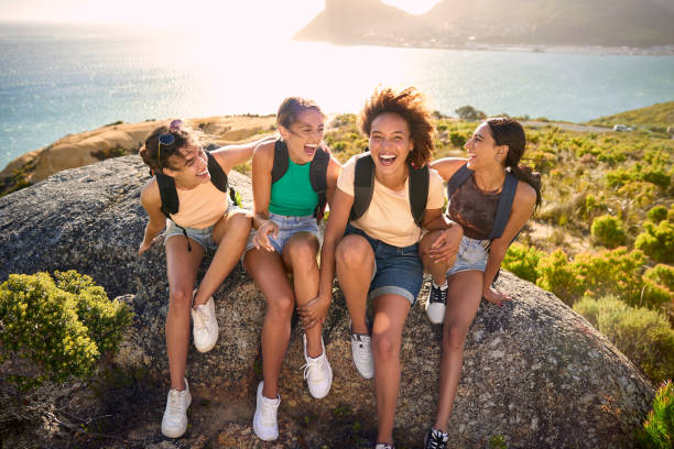 istock Female Friends With Backpacks On Vacation Taking A Break On Hike Through Countryside 1483237073