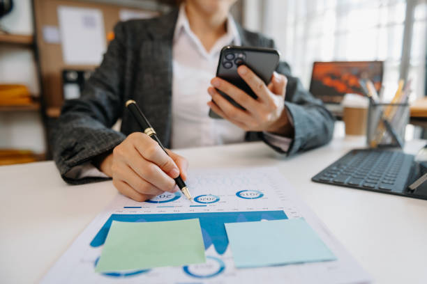 istock woman using tablet while sitting on cellphone at home. Beautiful girl relaxing while chatting on mobile phone at office 1483238901