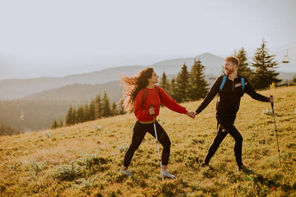 istock Young couple walking with backpack over green hills 1483239180