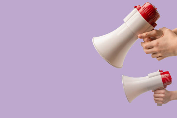 istock Megaphone in woman hands on a purple background. 1483239193