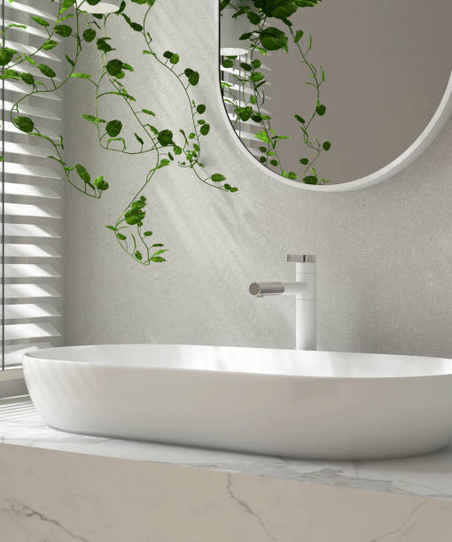 istock Modern marble vanity counter, white oval ceramic washbasin, mirror, creeper plant in sunlight from window blinds on luxury bathroom wall 1483240408