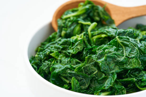 istock close up green cook leaf spinach salad in white bowl on white table background. leaves spinach or heap of spinach food salad 1483241873