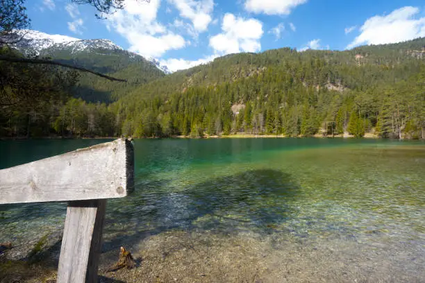 Photo of spring mountain lake landscape wooden fence Tyrol