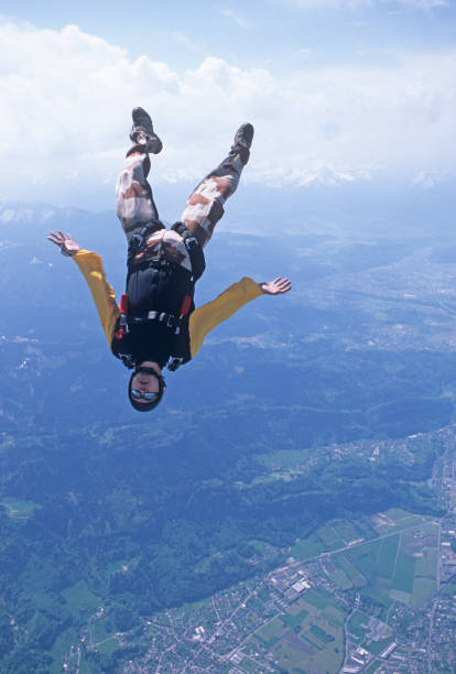 fallschirmspringer im freien fall über wolken - skydiving air aerial view vertical stock-fotos und bilder