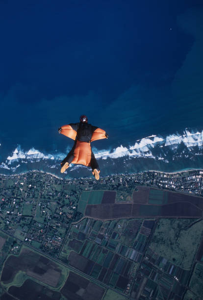 istock Wing suit flier soars above sea 1483242177