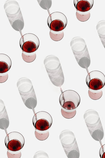istock Minimal pattern with glasses of red wine with sunlight shadows, Creative idea summer flat lay with Full Wine glasses and one empty on white, layout alcohol drinks, trend aesthetic photo 1483243694