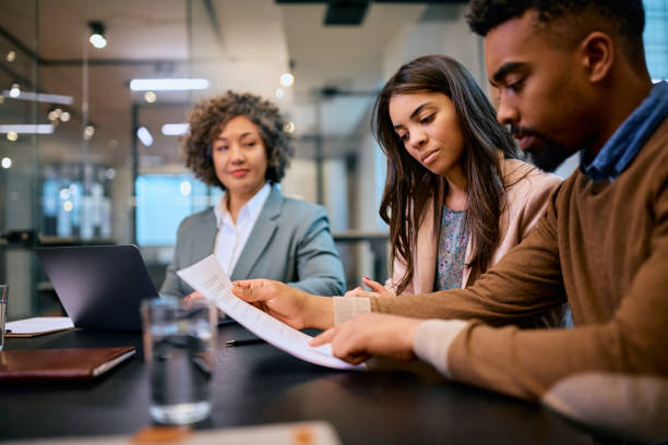 istock Young black couple analyzing paperwork on a meeting with insurance agent. 1483244018