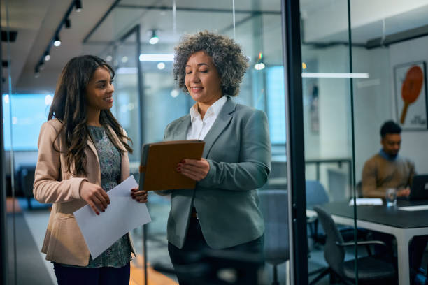 istock Happy businesswomen cooperating while working on touchpad in the office. 1483244197