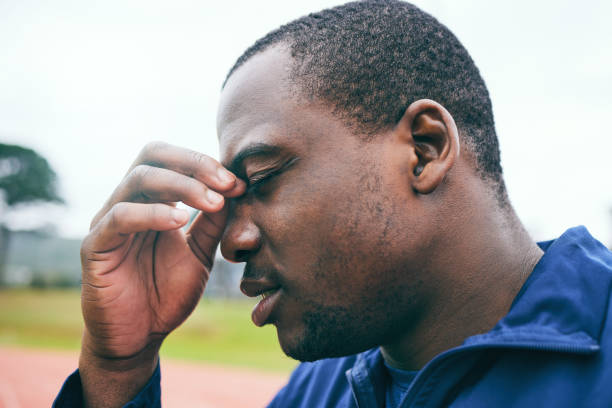 Headache, fitness and burnout with a sports black man holding his nose during an outdoor workout. Stress, exercise and mental health with a male runner or athlete training for cardio or endurance dolor de cabeza, estado físico y agotamiento con un hombre negro deportivo tapándose la nariz durante un entrenamiento al aire libre. estrés, ejercicio y salud mental con un corredor o atleta masculino entrenando para cardio o resistencia