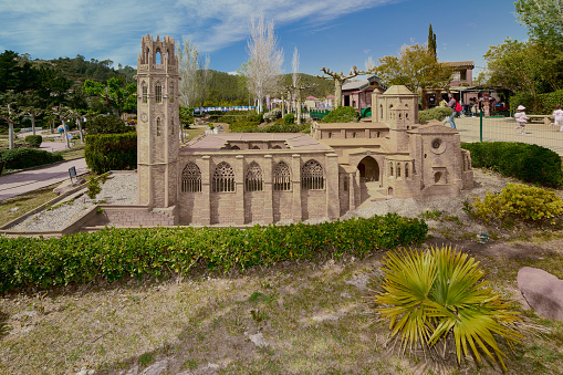 Torrelles de Llobregat, Catalonia - April 19, 2023: Close-up of the model of the old cathedral of Lleida in the Catalunya miniature park with children and people in the background.