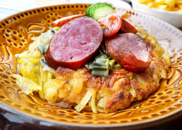 Traditional Swiss cuisine - Rosti with sausage on a plate, Switzerland.