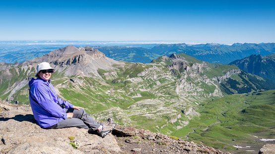 Mature asian woman enjoying the view of Swiss Alps from the top of Schilthorn, Switzerland