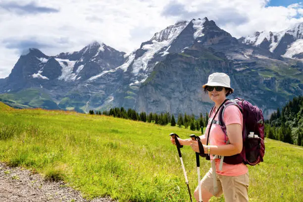 Mature woman hiking through the Mountain view trail in the Swiss Alps in the Jungfrau region.