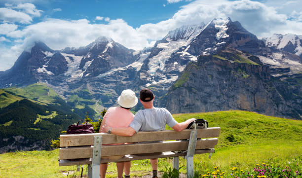 switzerland travel - coppia senior gode della vista della regione dell'eiger e della jungfrau nelle alpi svizzere - muerren foto e immagini stock