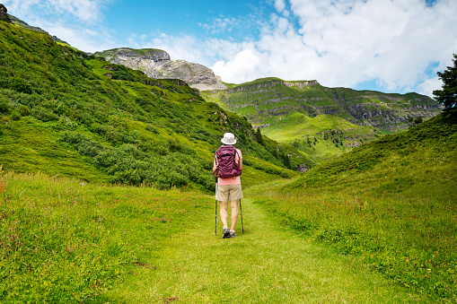 Senior woman hiking Switzerland alps. Mountain-view trail from Alimendhubel to Grutschlap