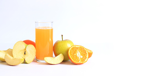 Tall glass with soluble multivitamins and fruits on a light background, empty space for text. Healthy food concept.