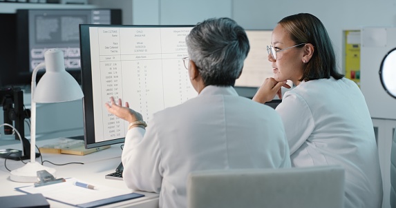 Science, hospital and women on computer for research, medical report and data analytics in laboratory. Healthcare, teamwork and female scientist in discussion for analysis, results and biotechnology