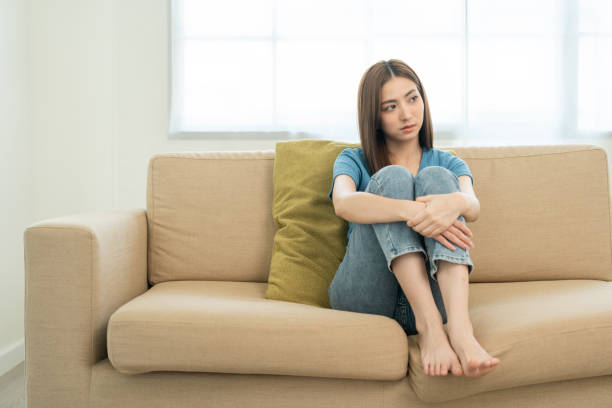 istock Depressed and Stressed asian woman on sofa. Crying sadness female alone in home problem in life. Unhappy asian woman headache Upset frustrated by problem love relationship feeling despair and anxiety 1483251990