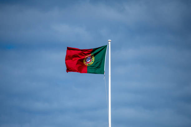 istock Portugal flag on cloudy sky 1483252093