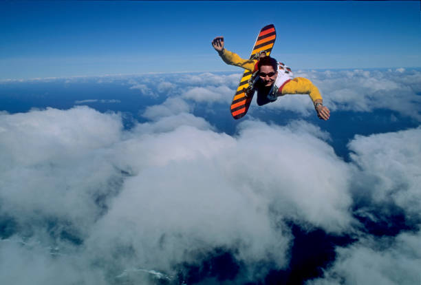 The skydiver plans down to the ground with an open parachute.