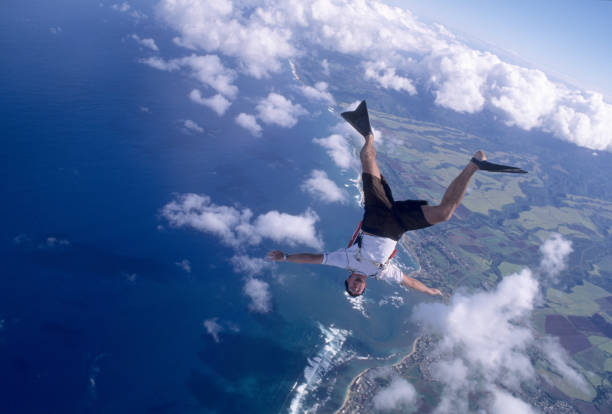 istock Skydiver with flippers free falls above clouds and sea 1483256194