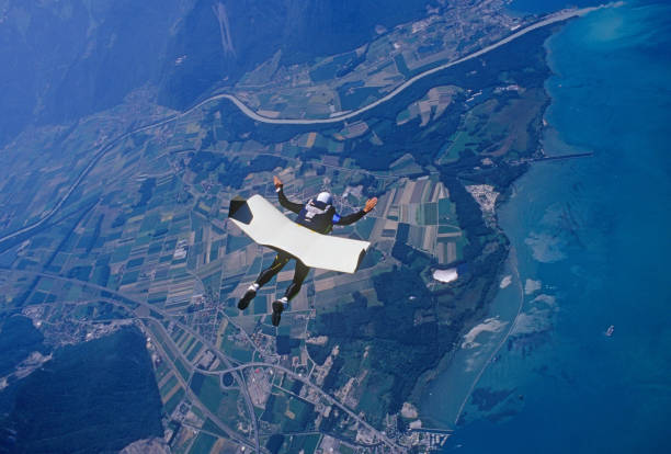 istock Skydiver glides with skyboard above coastline 1483257256
