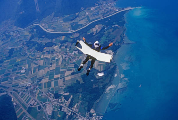 istock Skydiver glides with skyboard above coastline 1483257261