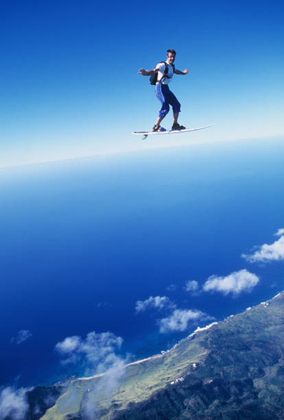 fallschirmspringer surft auf einem skyboard durch die luft - skydiving air aerial view vertical stock-fotos und bilder