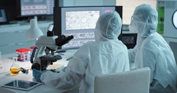 Collaboration, science and computer with a doctor women team in a laboratory for covid research in ppe uniform. Teamwork, innovation and experiment with scientist females working together in a lab