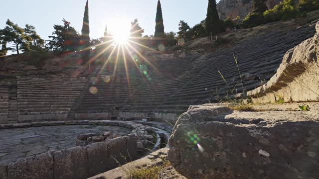 Sun shining through Greek Delphi Amphitheatre against clear sky