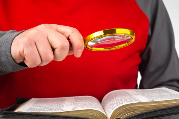 loupe pour lire un livre. bible ouverte. l’étude de la littérature. - magnification bible magnifying glass book photos et images de collection