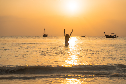 Young  woman swimming at sunset in Andaman sea