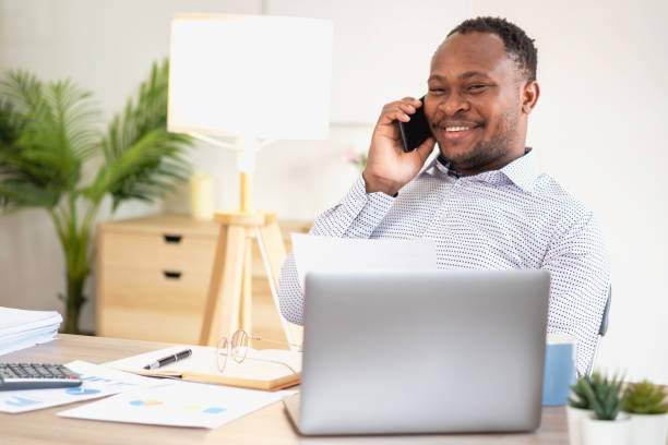 istock African black businessmen sit on mobile phones communicating with clients and making financial reports and studying annual profit analysis. An accountant checks the financial status of the company. 1483283031