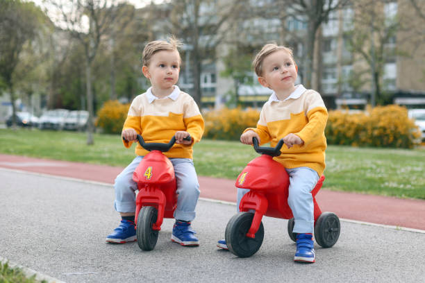 istock Twin brothers driving toy motorcycles 1483283716