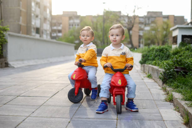istock Twin brothers driving toy motorcycles 1483283756